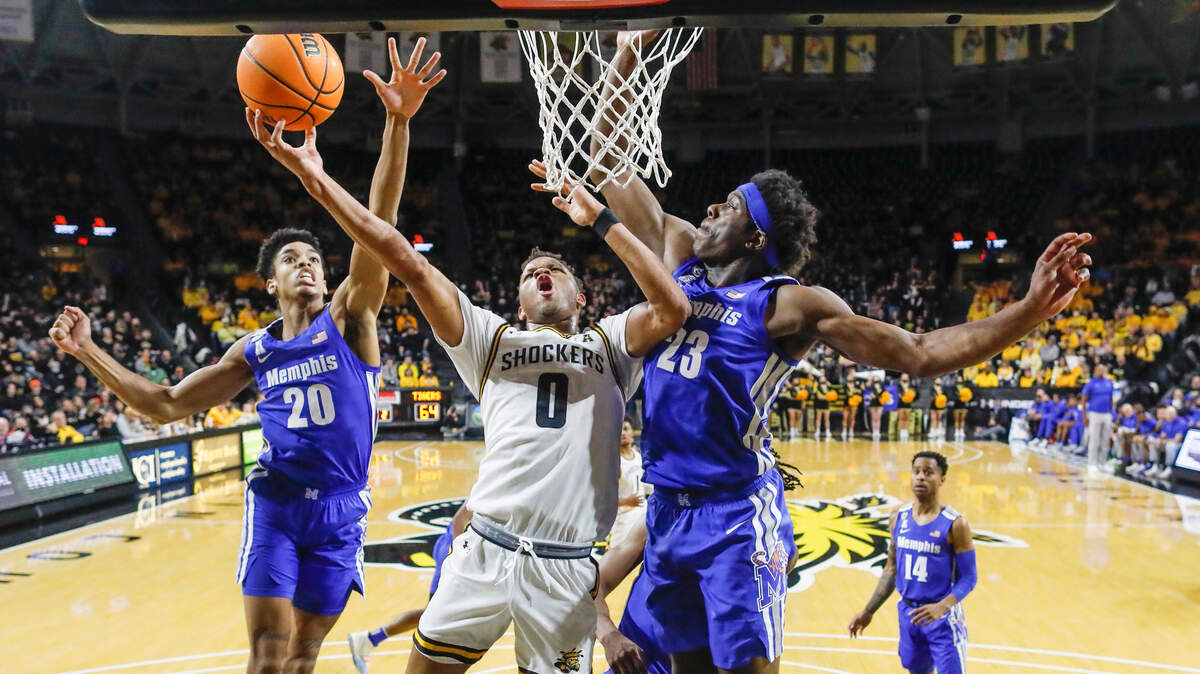Dexter Dennis tries to get a shot off against Memphis center Malcolm Dandridge, right, and Josh Minott during the second half on Saturday at Koch Arena.