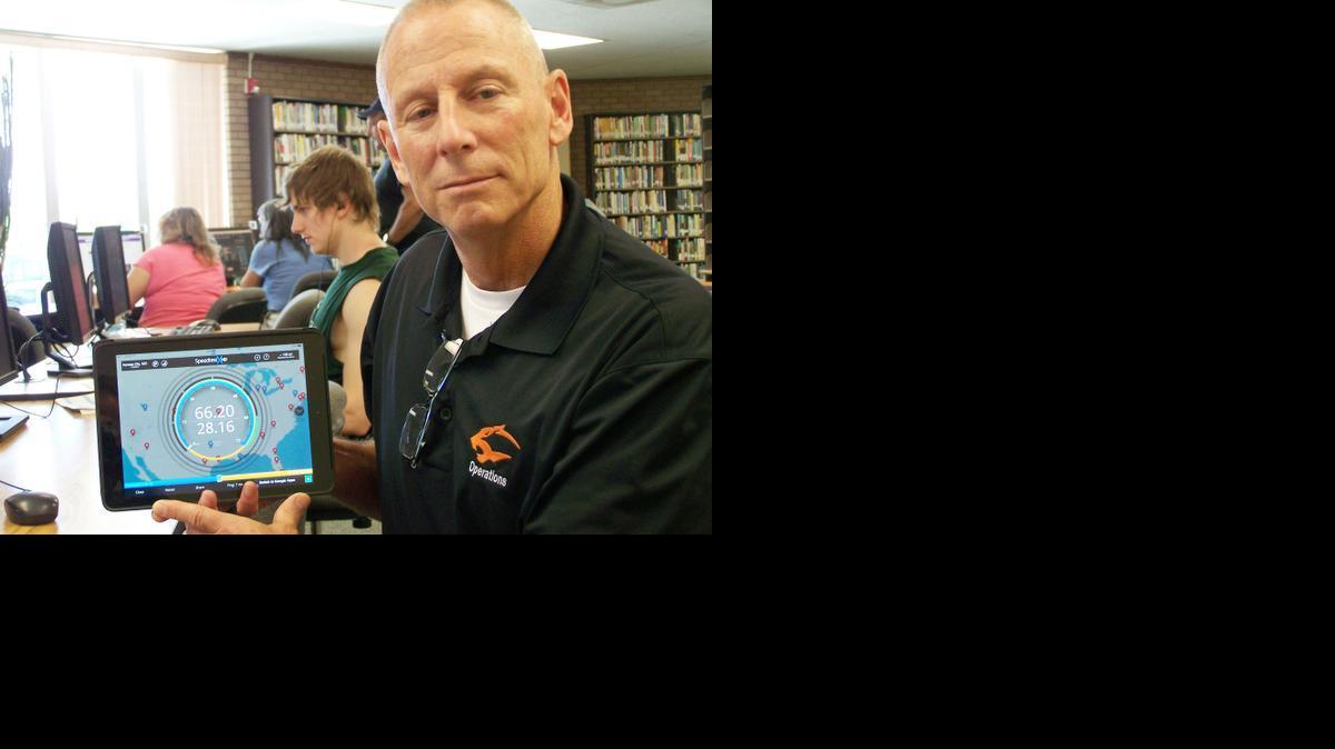 Ben Smith, vice president of Neosho County Community College, shows a tablet that displays the baud rate available to Chanute residents with the community broadband set-up.

