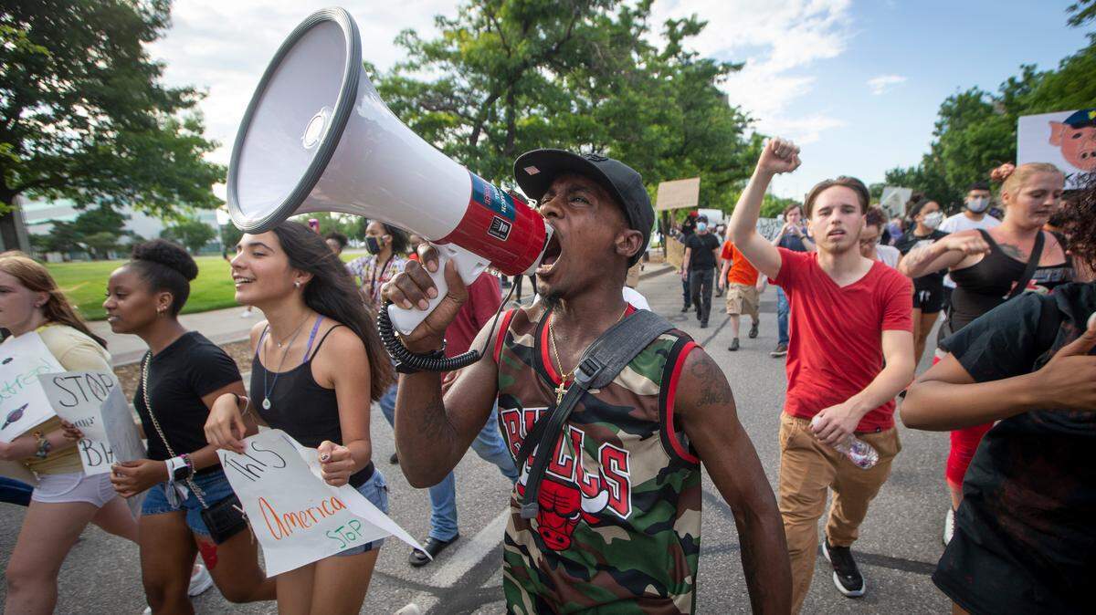 Willie Scott yells through a bullhorn while marching with other protesters down Main Street in Wichita recently.