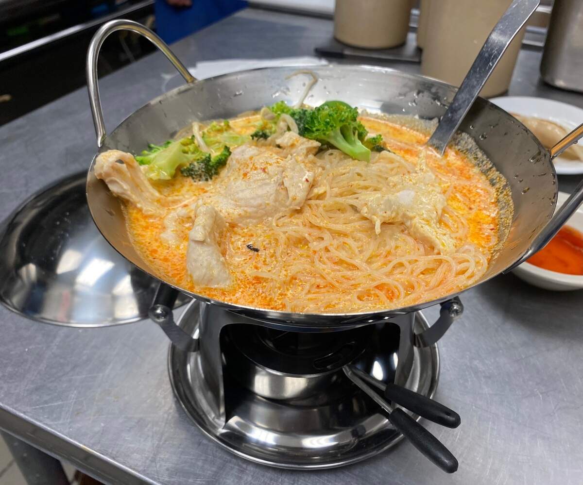 Yook and Mike Gan are serving some of their dishes, like this curry noodle soup, in individual stainless steel woks with heating elements.