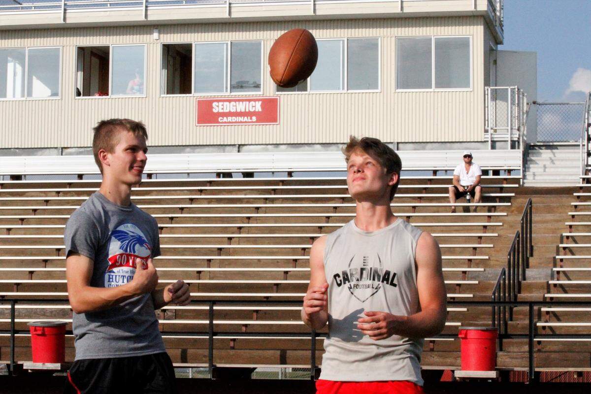 Sedgwick senior quarterback Hooper Schroeder (left) tosses the ball to his junior receiver and brother Kale Schroeder. The Cardinals are 3-0 so far in 2018.