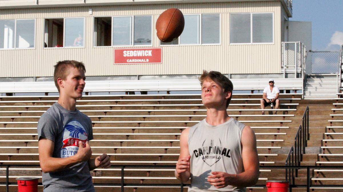 Sedgwick senior quarterback Hooper Schroeder (left) tosses the ball to his junior receiver and brother Kale Schroeder. The Cardinals are 3-0 so far in 2018.