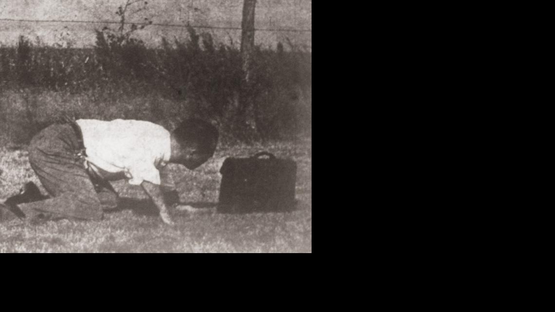 Lt. Clyde Bevis of the Wichita Police Department inspects a briefcase that was found at the Wichita Municipal Airport shortly after a suicide bombing in 1958. The briefcase belonged to bomber Forrest Don McCuiston, and police thought it might have contained more explosives. It was discovered later that it contained business papers belonging to McCuiston.