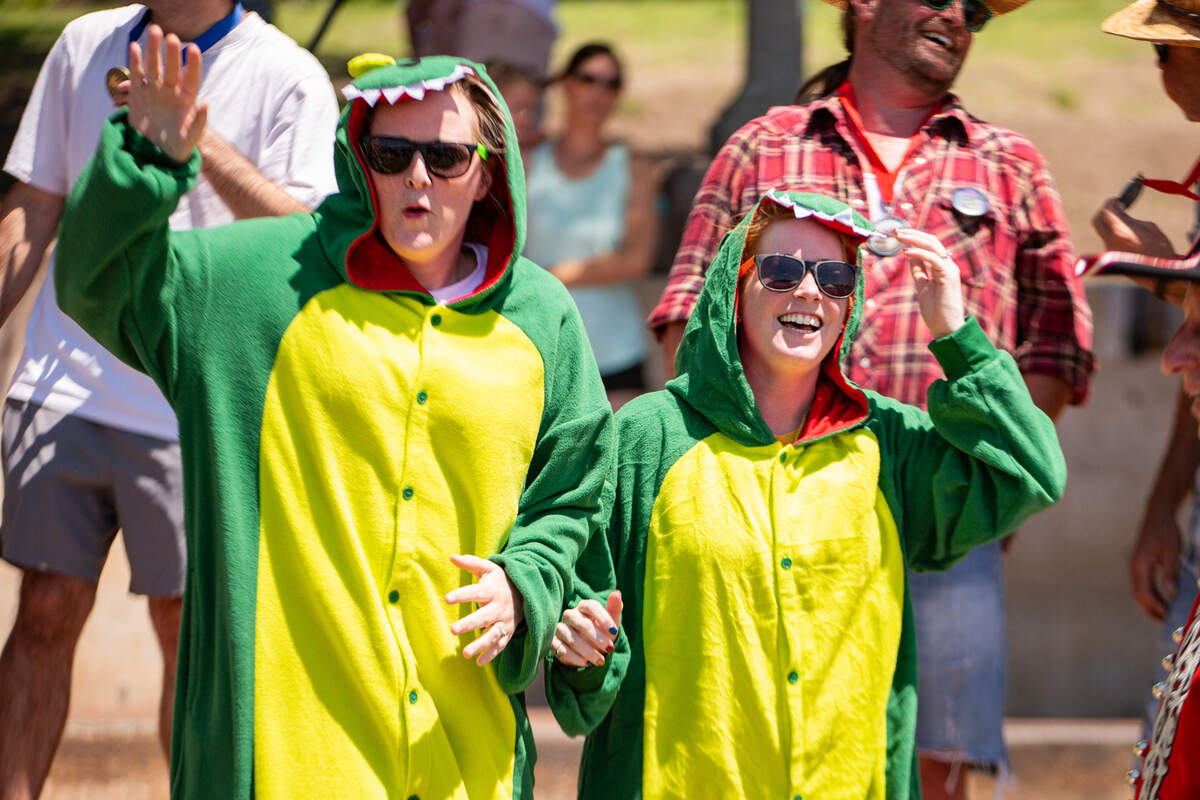 Nicole and Brook, members of a dinosaur-themed team, celebrate after they win “most creative” costumes during the cowboy bathtub races on June 1. The two were part of a four-person group that competed on the Arkansas River.