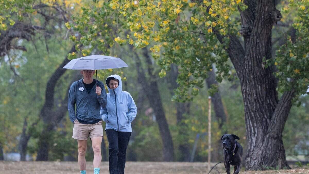 Justin Moore and his wife, Tracy Williams, walk with their dog through a light rain at Sedgwick County Park during the fall of 2023.