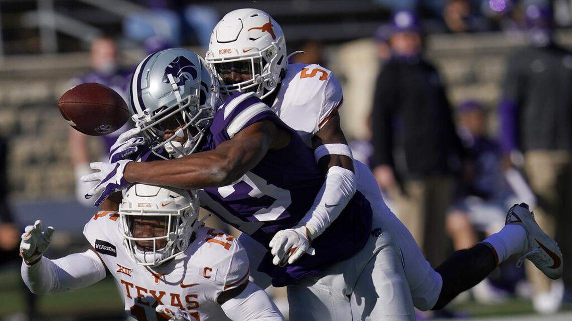 Texas defensive backs D’Shawn Jamison (5) and Chris Brown (15) break up a pass intended for Kansas State wide receiver Chabastin Taylor (13) during the first half of an NCAA college football game in Manhattan, Kan., Saturday, Dec. 5, 2020. (AP Photo/Orlin Wagner)