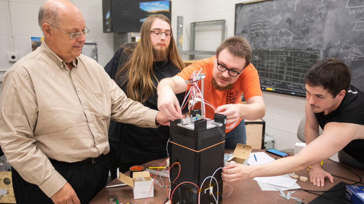 Wichita State University physics professor Nick Solomey, far left, is building a space-based neutrino detector through a NASA award. It could help answer mysteries of the universe and physics. He is photographed here with graduate students in physics, left to right, Brian Doty, Jonathan Folkerts and Trent English. They are working on a prototype detector in a WSU lab. This detector wonÕt fly in space but will be allow them to do work on the next phase which will fly in space. (July 22, 2021)