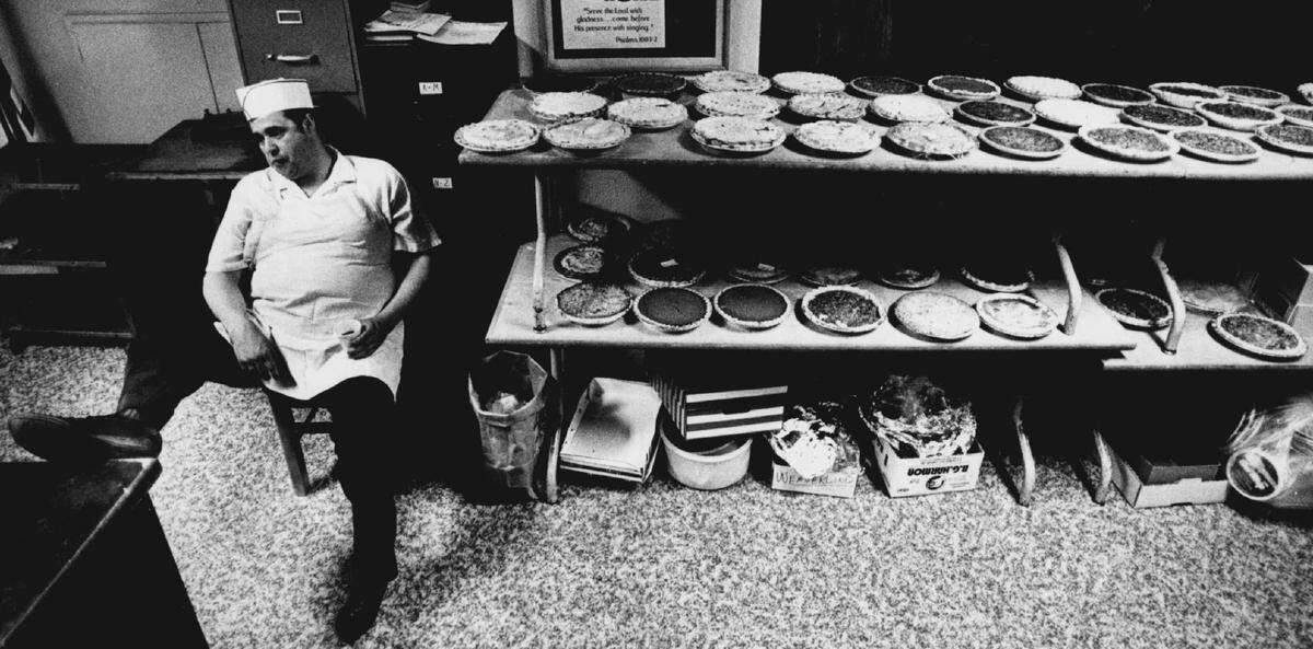 A photo from 1986 shows volunteer Lance McClure taking a coffee break beside some of the pies that were to be served at the annual St. Paul’s Chicken Noodle Dinner.