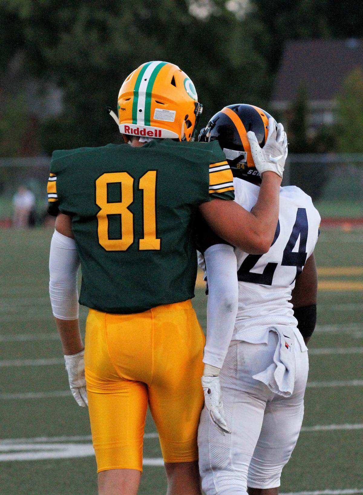 Bishop Carroll senior receiver Mason Baalman (81) and Wichita Northwest’s Quinton Kinchion (24) embrace after a play during the Grizzlies 23-22 win over the Golden Eagles on Friday night. (Aug. 31, 2018)