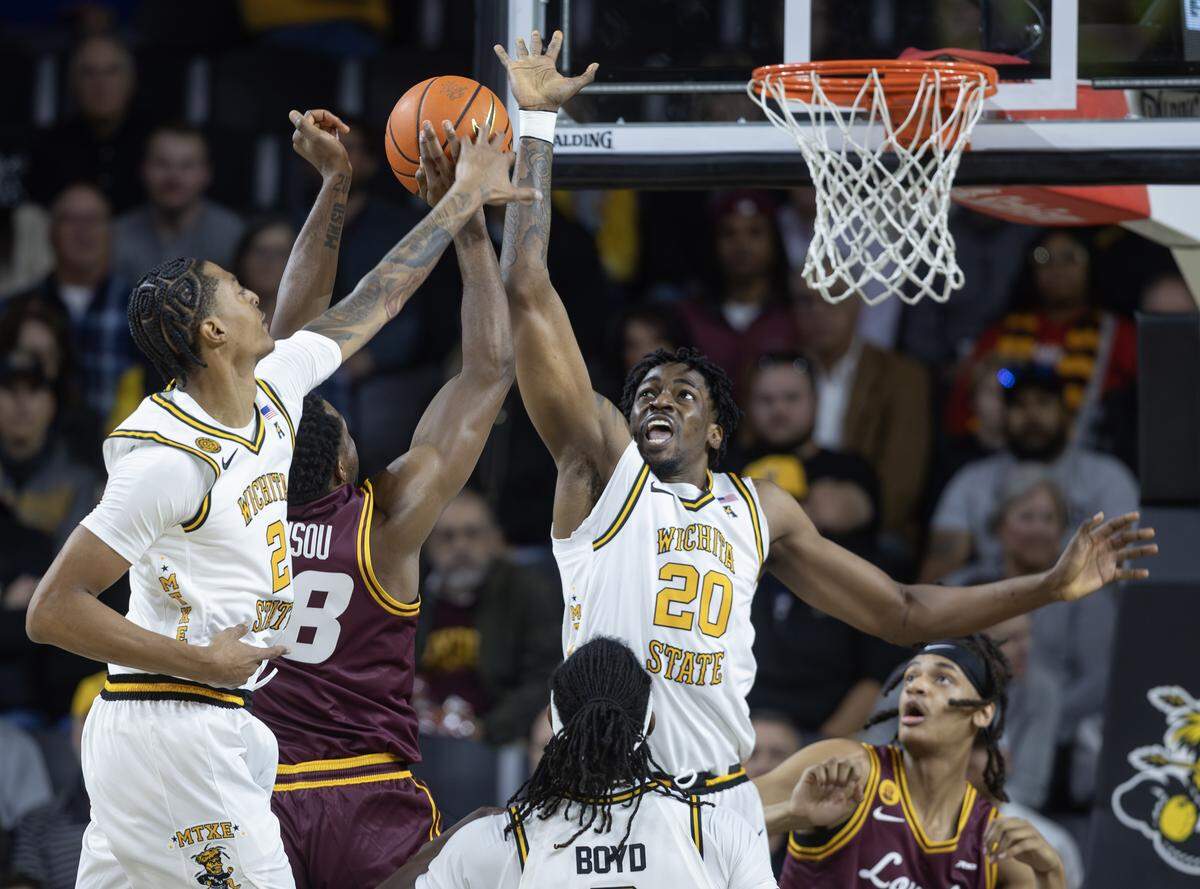 Jaret Valencia, left, defend Loyola shooter Kymany Houinsou during the first half of their game at Koch Arena.