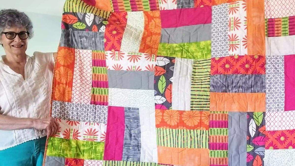 “Whenever you need a hug, grab a quilt!” Dottie Evans of the new White Crane Designs likes to say. “When some friends lost most everything in the Andover tornado last year, I made quilts for the children so each could have a hug whenever they needed one. One was made of bright modern fabric called Stockholm by Robert Kaufman. It was a big hit with the teenage recipient.”