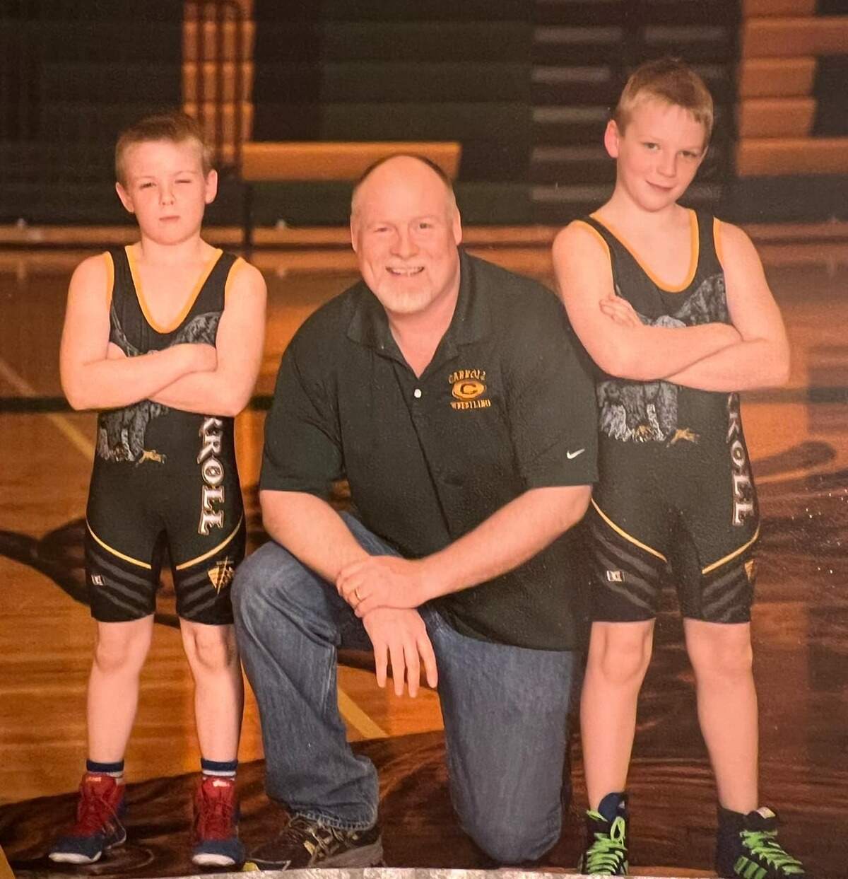 Brady Duling (left) poses for a picture with his father, Rob (middle), and older brother, Sam (right), at a Bishop Carroll youth wrestling camp.