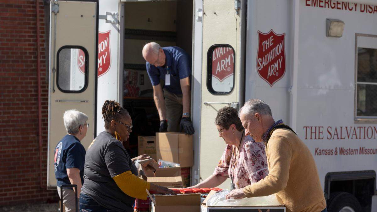 Volunteers and staff members from the Salvation Army load up orders for people taking advantage of the Salvation Army’s mobile food pantry at Goldenrod Park on Monday. The mobile food pantry is designed to relieve stress in neighborhoods that are considered “food deserts.”