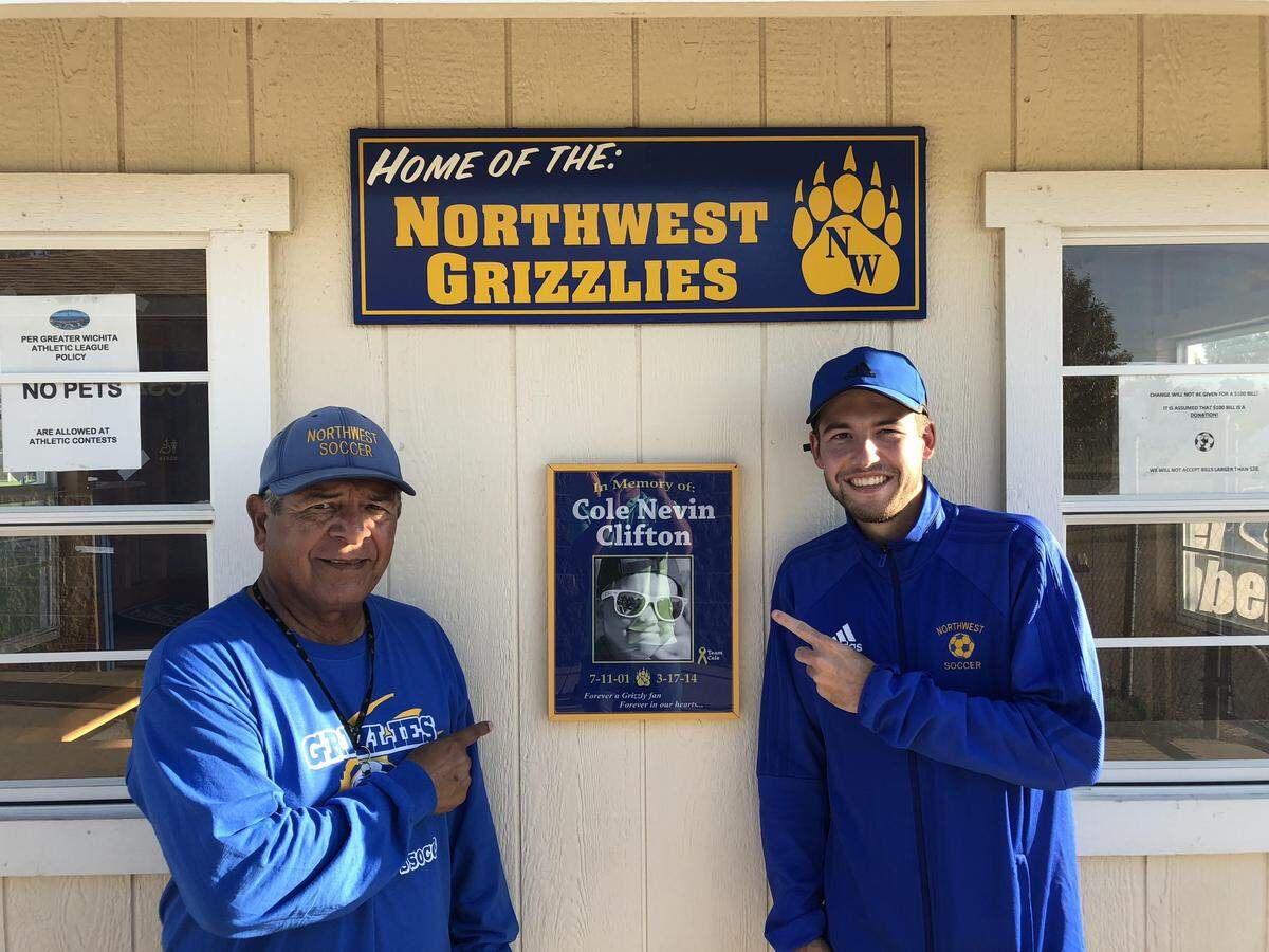 Wichita Northwest boys soccer coach Bobby Bribiesca and assistant Austin Clifton pose with a plaque commemorating former ball boy and Clifton’s brother, Cole.