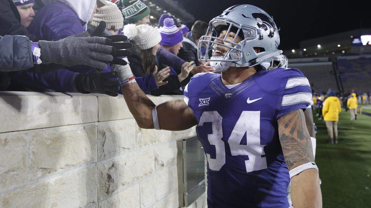 K-State running back Alex Barnes (34) shakes hands with fans as he circles Bill Snyder Family Stadium. (November 17, 2018)