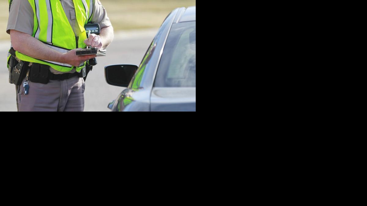 A Wichita police officer writes a traffic ticket. 

