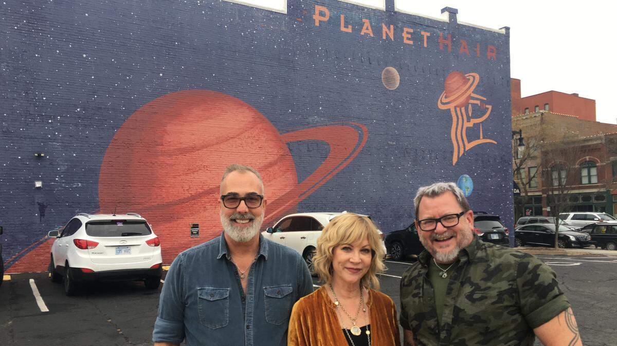 For the first time in their 27 years downtown, Planet Hair owners Graham Ross, left, and Linda and Tod Ernst own the parking lot to the west of their salon at 504 E. Douglas. This is significant because it preserves parking for the business and the future visibility of their celestial mural, which is one of the best-known murals in the city.