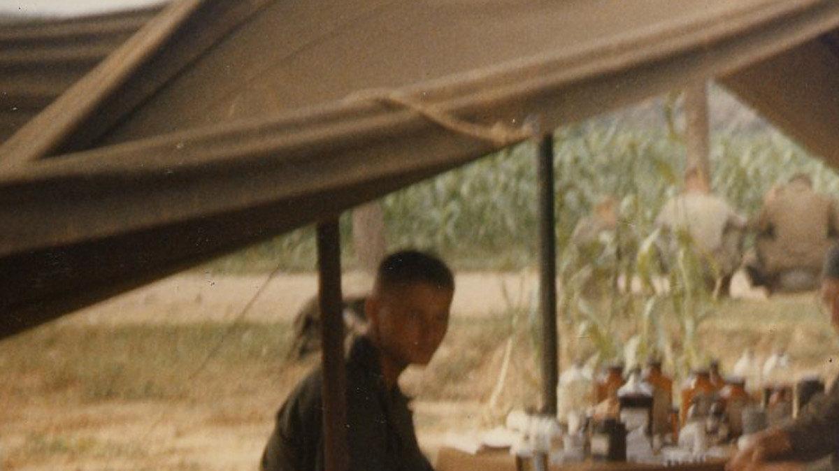 Fr. Kapaun (bottom right, with helmet) coverses with soldiers in Korea.  Date unknown