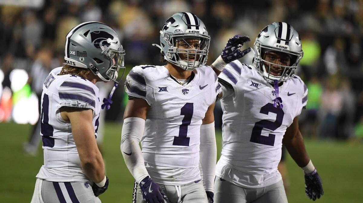 Kansas State Wildcats safety Jet Dineen (14) cornerback Keenan Garber (1) and safety Colby McCalister (2) celebrate after a defensive stop during the second half against the Colorado Buffaloes at Folsom Field.