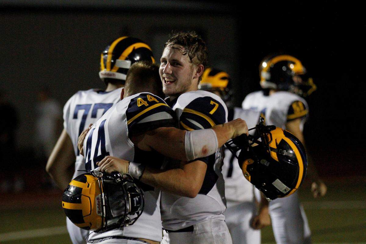 Wichita Northwest senior linebacker Josh Carter (44) hugs junior quarterback Reagan Jones (7) after the Grizzlies 23-22 win over the Bishop Carroll Golden Eagles on Friday night. (Aug. 31, 2018)