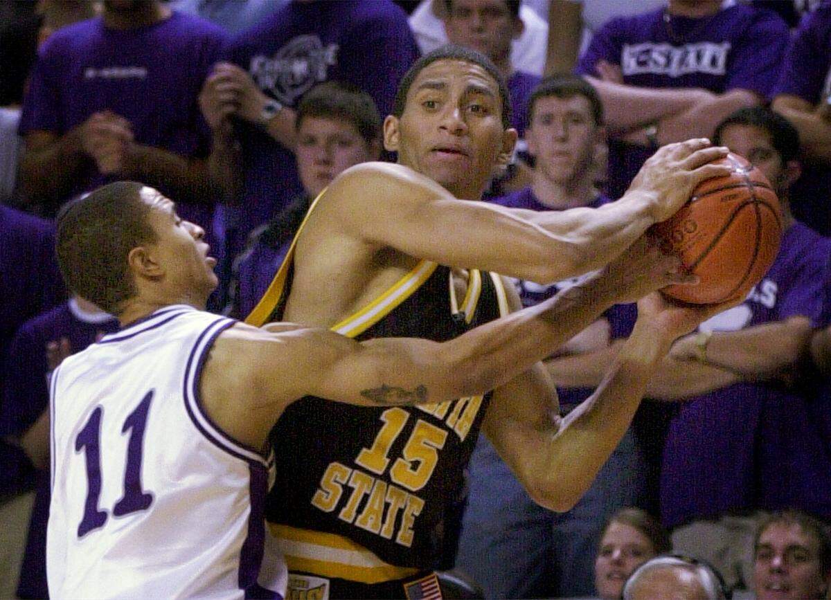 Kansas State guard Larry Reid (11) tries to steal the ball away from Wichita State guard Terrell Benton (15) in the second half Wednesday, Dec. 5, 2001 at Bramlage Coliseum in Manhattan, Kan. Wichita State won 65-56. (AP Photo/Charlie Riedel)