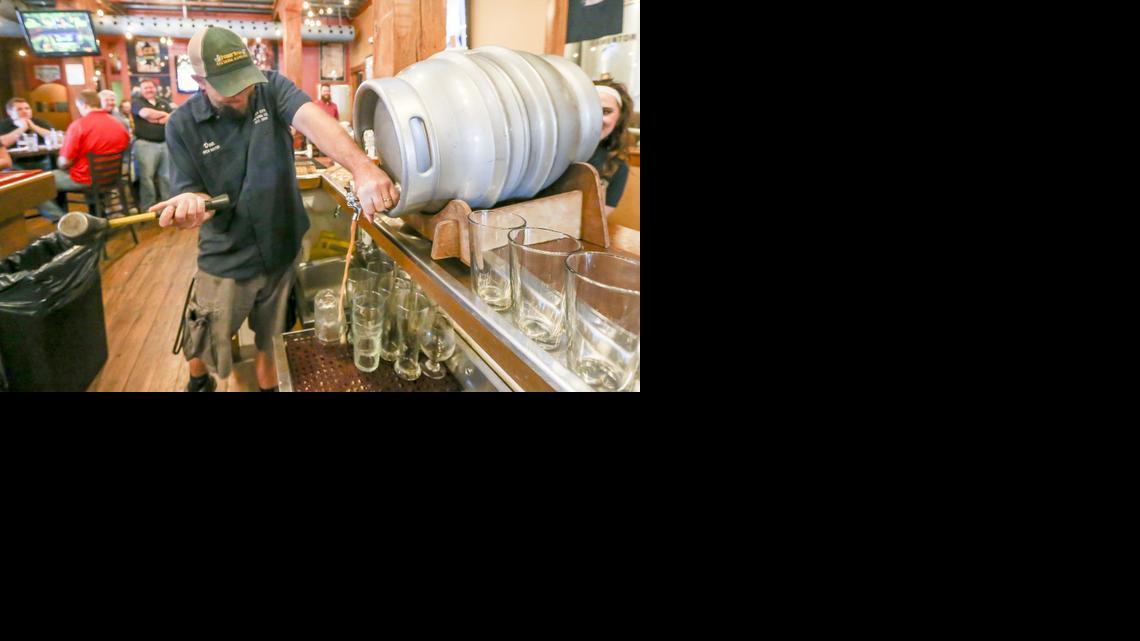 River City brew master Dan Norton taps a firkin at the restaurant. 

