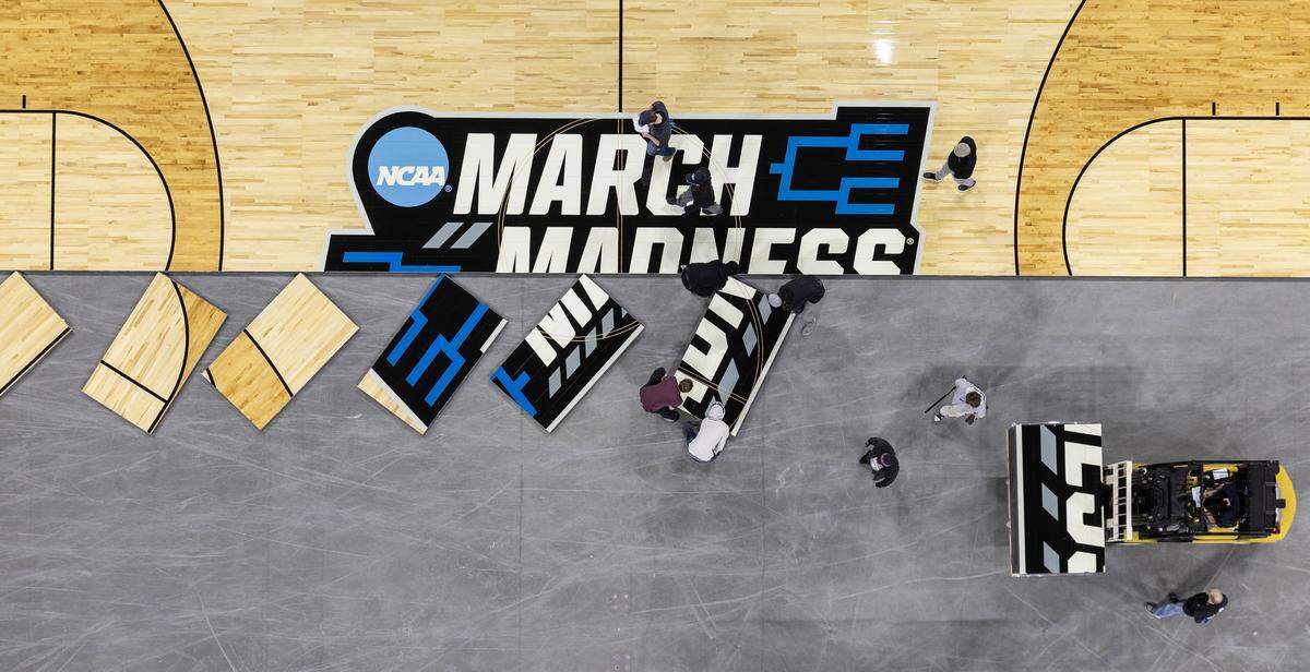 Workers install the court for the NCAA Tournament at Intrust Bank Arena.