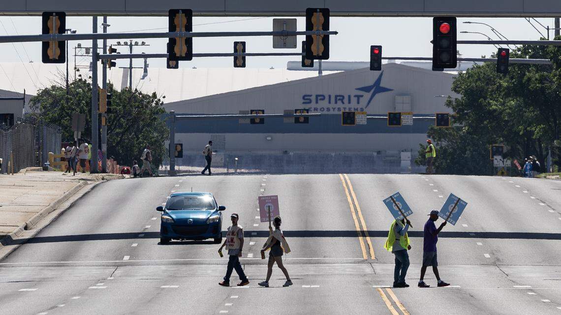Striking workers picket outside the Spirit AeroSystems factory on Saturday morning. Members of the Machinists union voted down a proposed contract from Spirit earlier this week.