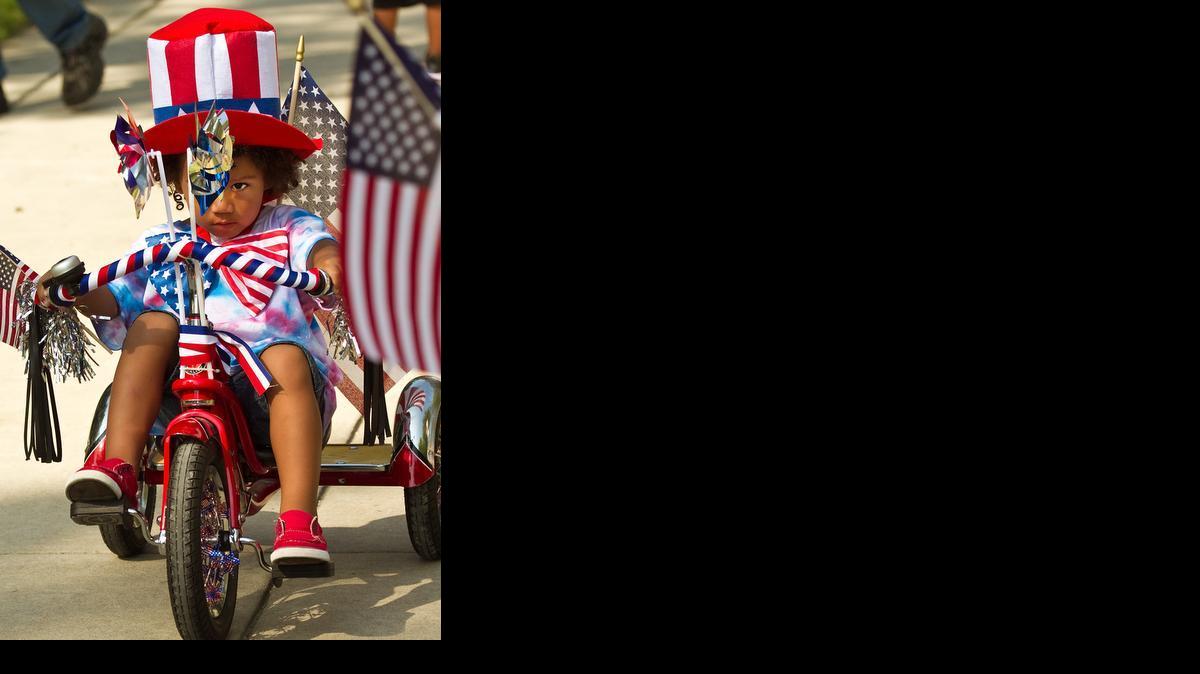 Brilynn Cole joins the parade of bikes, wagons and scooters decorated for the annual Riverside Citizens Association 4th of July Pancake Breakfast and Children’s Parade in Central Riverside Park in 2012.

