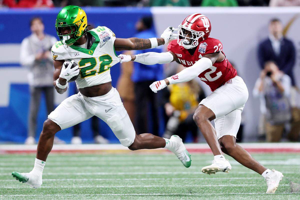 Jay Harris #22 of the Oregon Ducks runs against Jamari Sharpe #22 of the Indiana Hoosiers during the first quarter in the 2025 College Football Playoff Semifinal at the Chick-fil-A Peach Bowl at Mercedes-Benz Stadium on January 09, 2026 in Atlanta, Georgia.