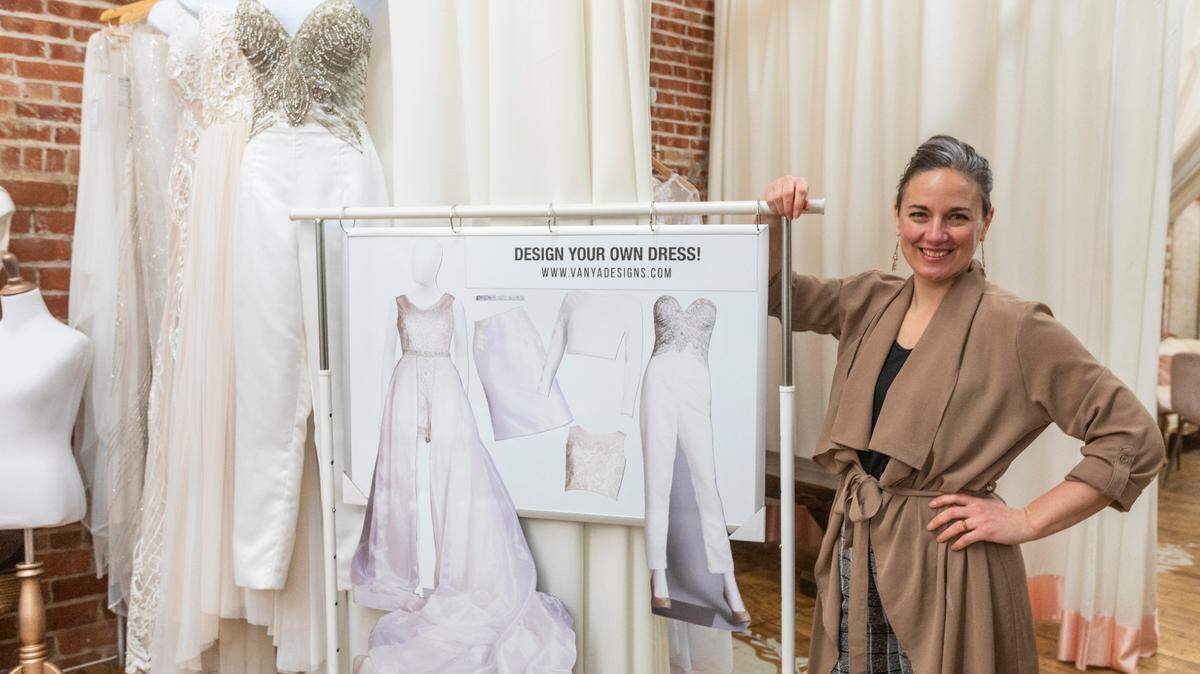 Alicia Ybarra of Vanya Designs shows the two-foot tall interactive magnetic paper dolls she’s using at this weekend’s Bridal Fair so brides can play around with different designs from her collection.