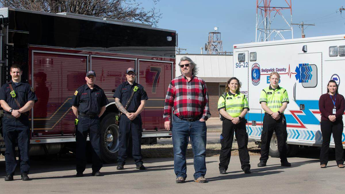 Roy Wenzl, center, stands with emergency personnel who helped save his life on February 2, 2021 when he had a pulmonary embolism. From left to right, Wichita firefighter Garrett French, Capt. Rocky Bumgarner and firefighter Dalton Scott, EMS paramedics Sarah Cindric and Stuart Fayette and and 911 dispatcher Kaylyn Perez. (March 10, 2021)