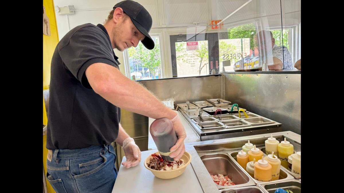 Kristopher Rue assembles a bowl at Express Kitchen, a new concept by the owners of The Kitchen.