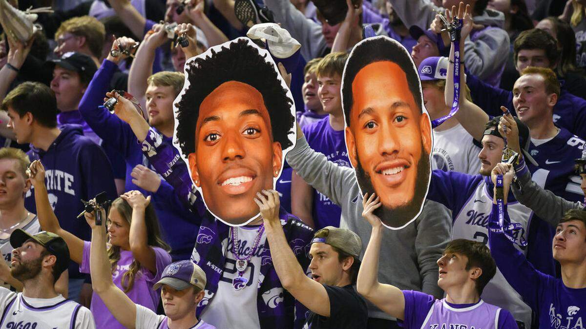 Kansas State fans hold up photos of forward Nae’Qwan Tomlin, left, and guard Markquis Nowell during the first half of the team’s NCAA college basketball game against Oklahoma State in Manhattan, Kan., Tuesday, Jan. 10, 2023. (AP Photo/Reed Hoffmann)
