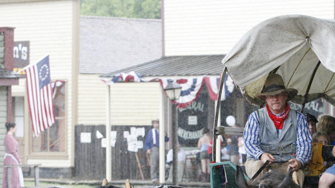 A covered wagon drives through the rain down the streets of Cowtown during their Celebrate America event Saturday. (July 3, 2010)