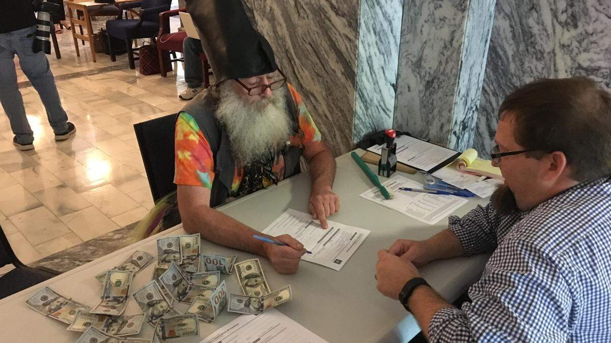 Vermin Supreme, a political performance artist who travels the country, files for Kansas attorney general on Friday. He paid his filing fee with $100 bills.