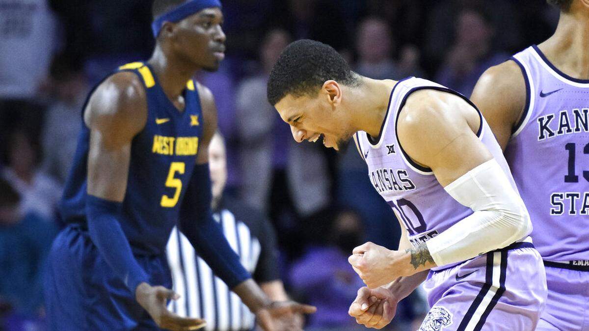 Kansas State guard Mike McGuirl, right, celebrates as time runs out in the team’s NCAA college basketball game against West Virginia in Manhattan, Kan., Monday, Feb. 14, 2022. Kansas State won 78-73. (AP Photo/Reed Hoffmann)