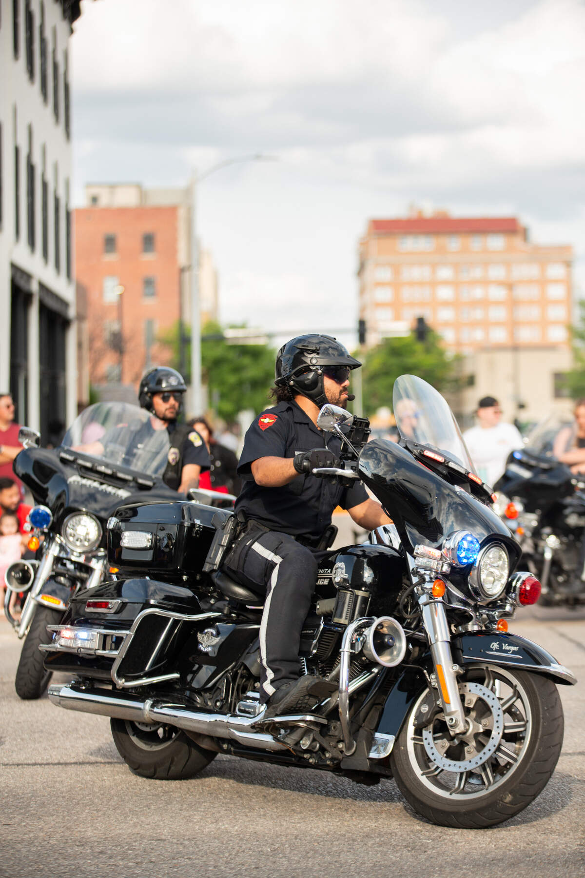 Members of the Wichita Police Department motorcycle unit drive in circles before the start of the Star Lumber Sundown Parade. The parade helped kick off the start of the nine-day Riverfest on Friday.