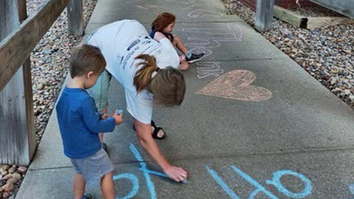 Members of Wichita Hearts for Healers write chalk messages to thank health-care workers at Wesley Medical Center
