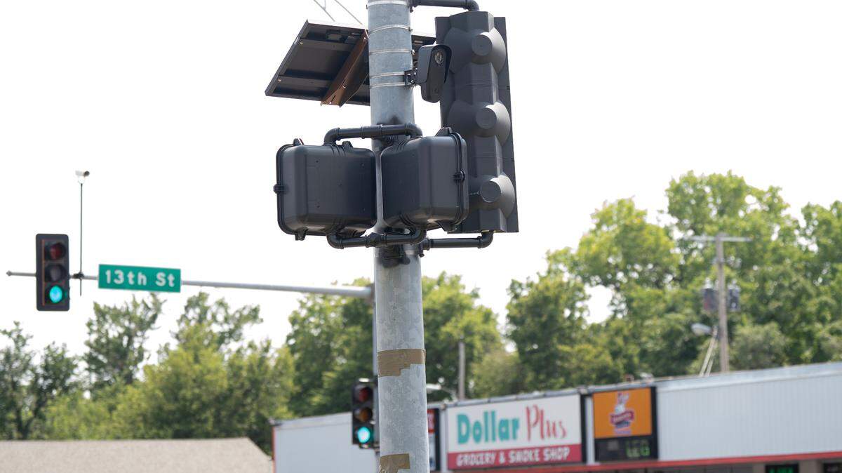 A Flock Safety device hangs from a light pole at the intersection of 13th and Grove where police are testing the company’s gunshot sensors. Police have been using the company’s license plate readers for several years but recently announced they would purchase the company’s gunshot sensors as well.