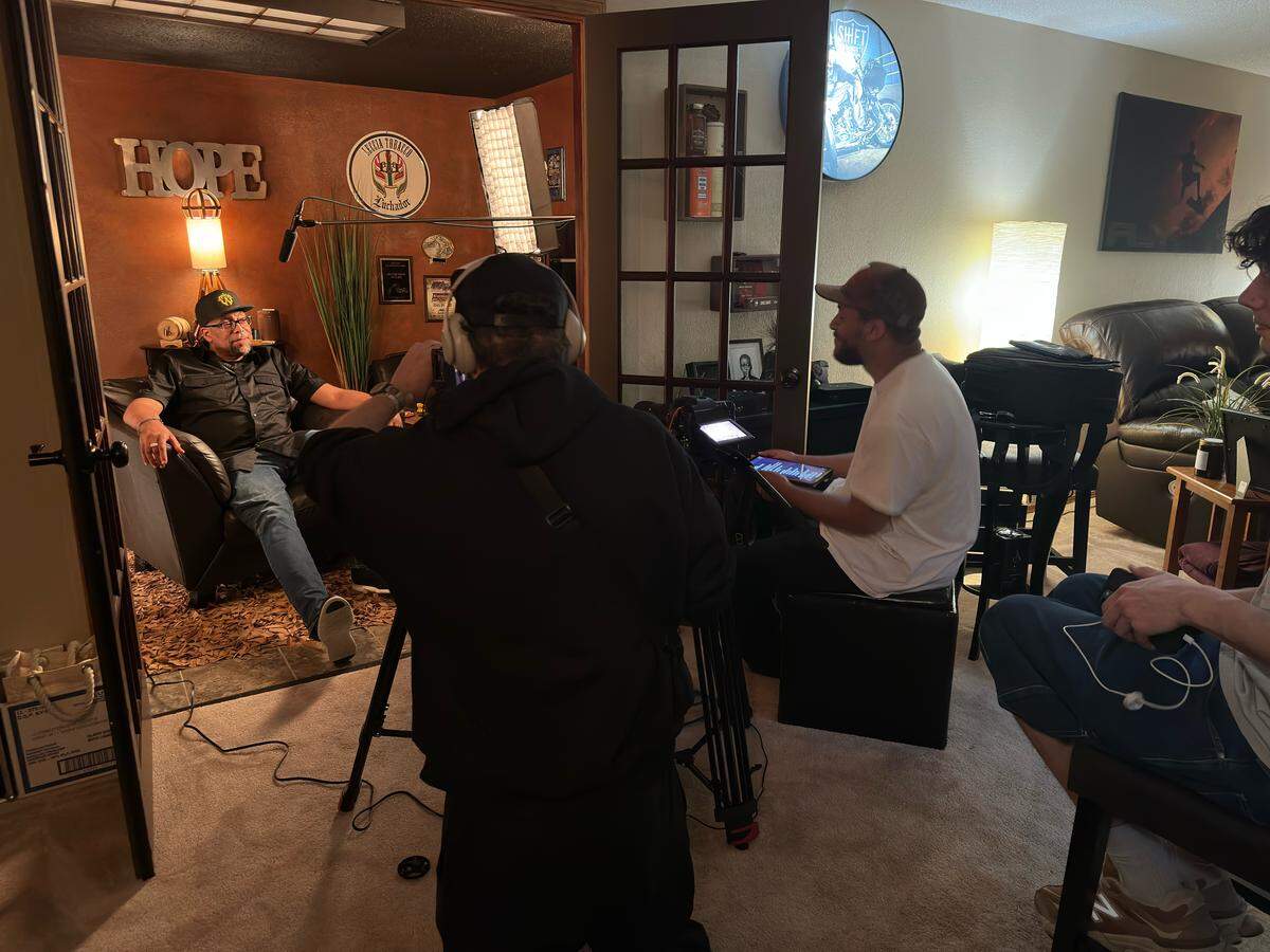 Caleb Carnell, at right in hat, and his father, Keith Hope, at left being interviewed, on the set of “The Madwest Theory: A Danoiz Documentary.”