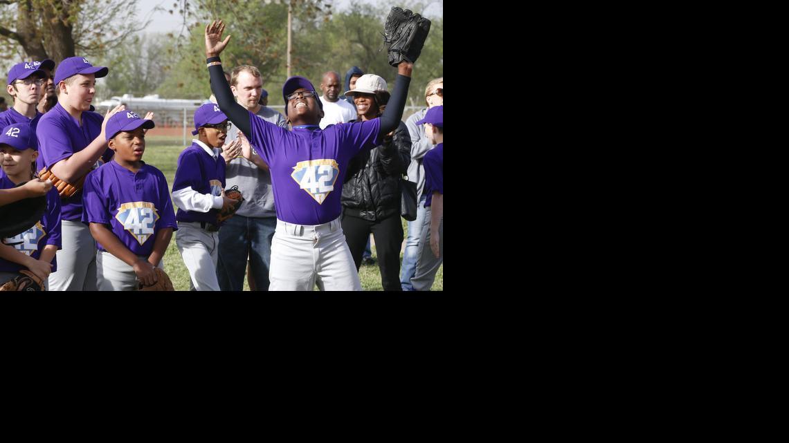 Tayshawn Wilson throws his hands in the air after his name was announced during the opening night for League 42, a youth baseball league. The league has 16 teams with 220 kids ages 5-13. (April 27, 2014)

