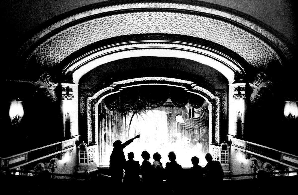 Harry Watts (left), manager of community relations at Southwestern Bell, points out some of the Orpheum theater’s intricate decor to a tour group Tuesday night.
