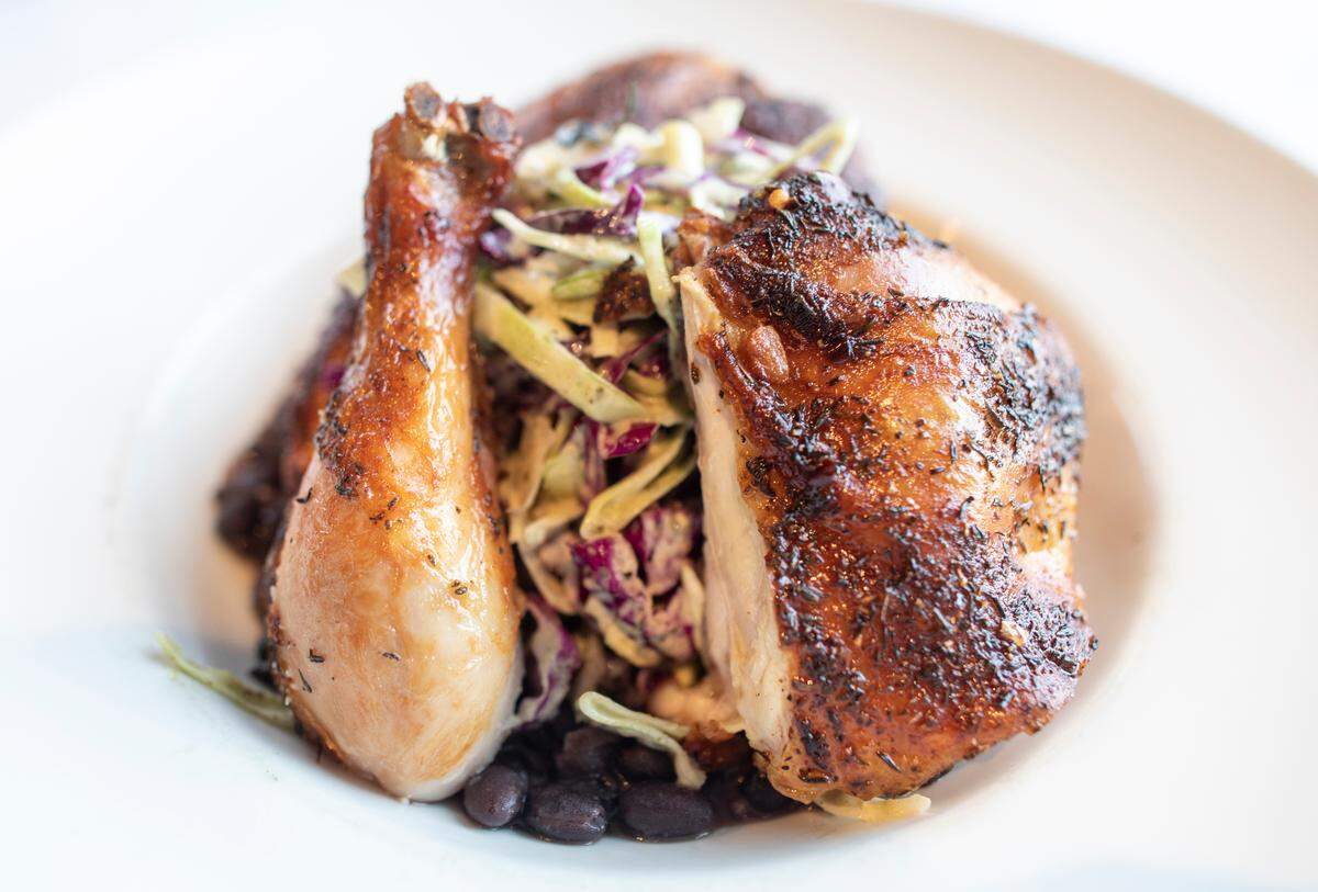 Chef Jordan Rickard has recreated the menu at Greystone Restaurant, taking off the high-seafood items and replacing it with dishes like this smoked jerk chicken, served with baked black beans and poblano coleslaw.