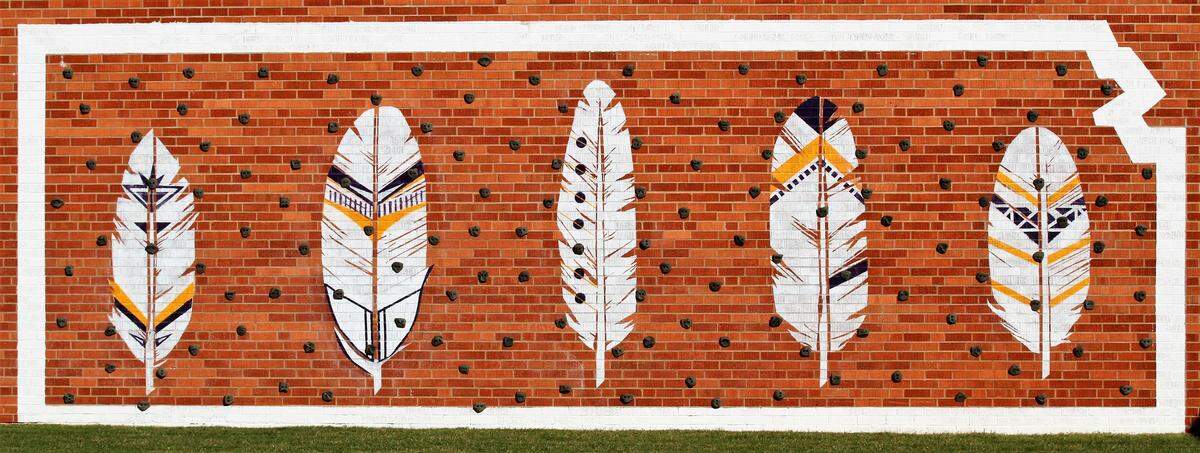 A mural outside Medicine Lodge High School, depicting feathers across an outline of the state of Kansas. (Sept. 27, 2018)