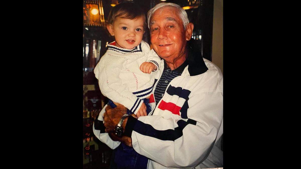 Ed Kriwiel, a legendary Kapaun Mt. Carmel football coach, holds his grand son, Clay Cundiff, who has grown up to become a sophomore tight end on the Wisconsin football team. The Badgers will play Saturday at Soldier Field in Chicago, where Kriwiel once was a football star.
