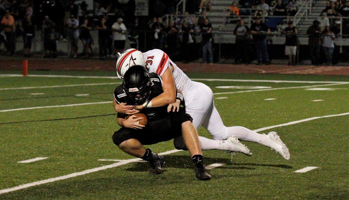 Maize junior defensive end Keaton Robertson sacks Campus senior quarterback Evan Kruse during the Eagles’ 21-0 win over the Colts on Friday night. (Sept. 14, 2018)