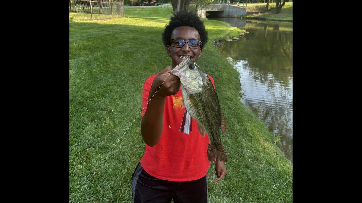 Claude Hodges Jr. smiles after catching a bass at a pond near his home in east Wichita. The 14-year-old Wichita boy was fatally shot by his mother in January.