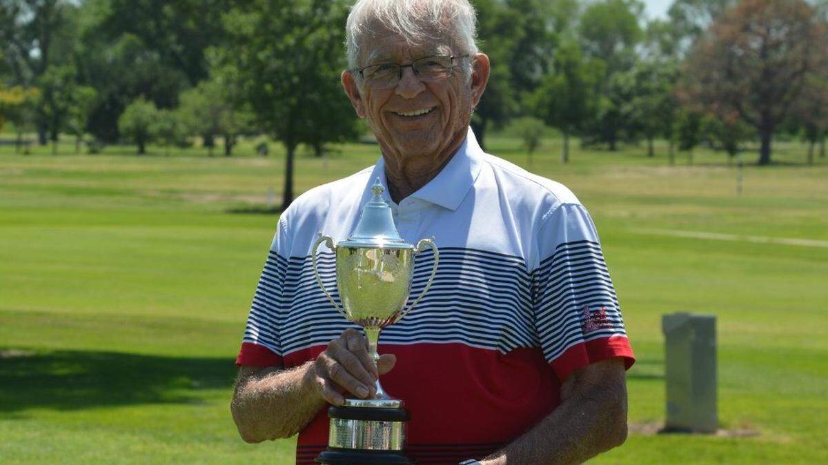 Rusty Hilst holding the golf award that was named after him and goes to the boy junior player of the year.