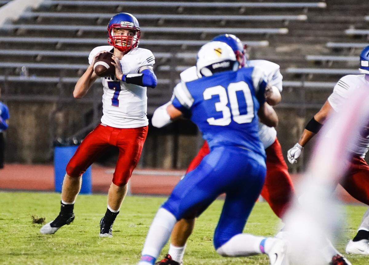Former South high Titans quarterback Evan Kruse steps back for a short pass over Kapaun Mt. Carmel Shane Channel (30) in the second quarter Friday night at Cessna stadium.(Sept 23rd, 2016)